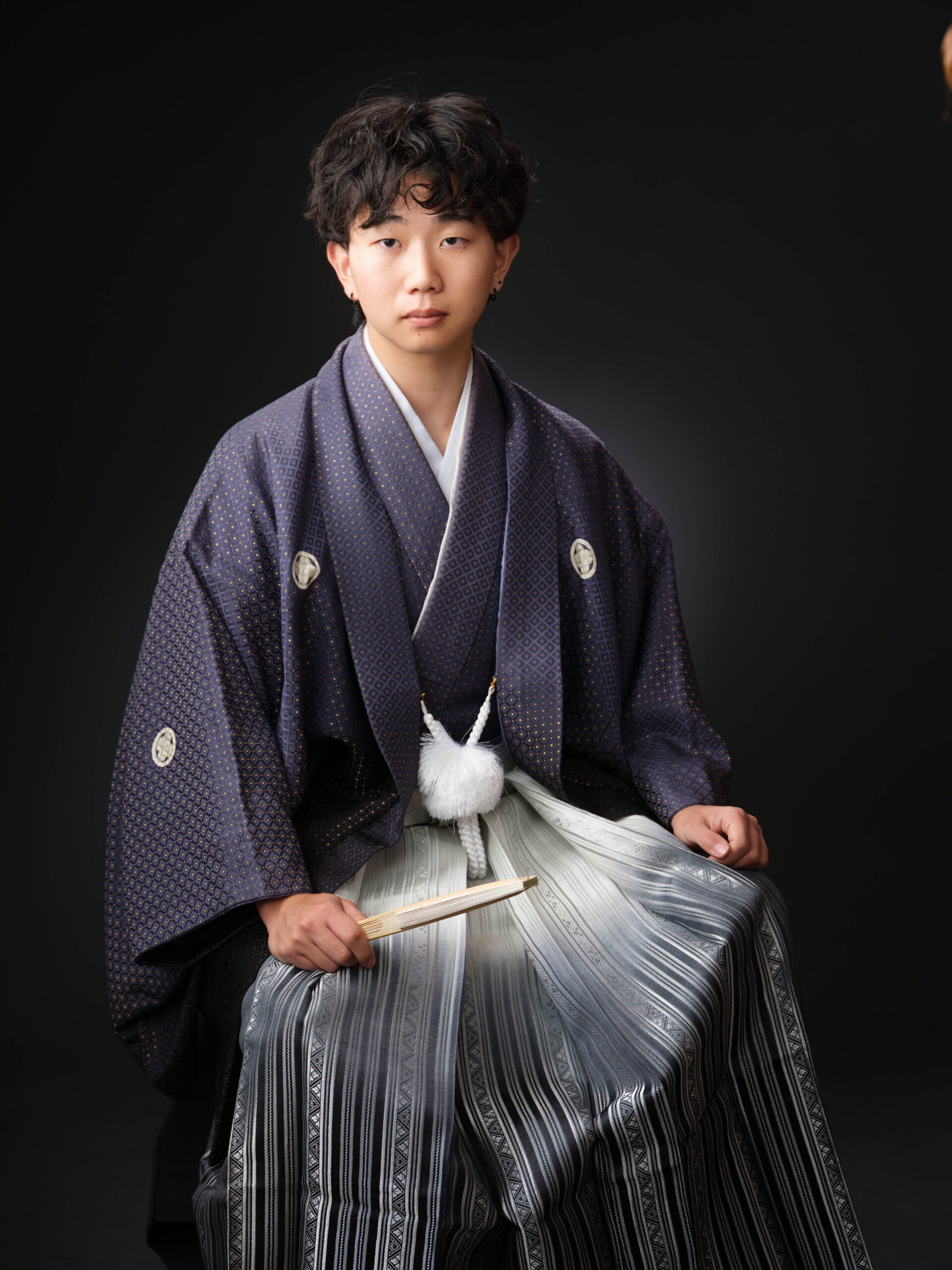紺の羽織袴を着た男性の座り姿のスタジオ撮影