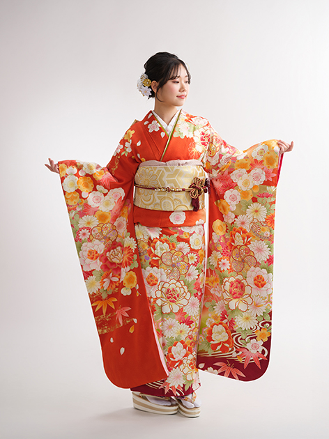 朱色の振袖を広げたスタジオ撮影